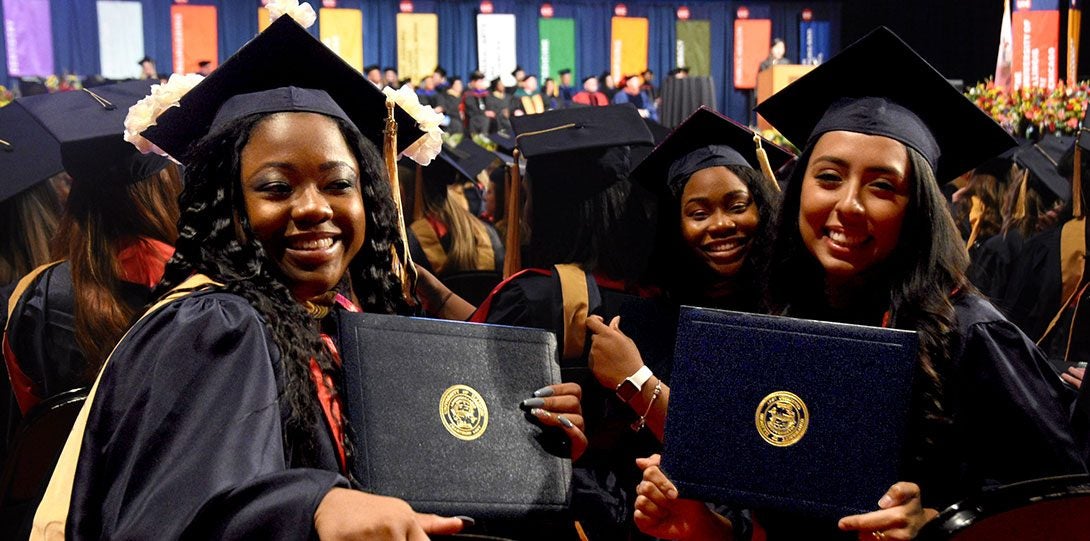 Three MSW graduates with diplomas